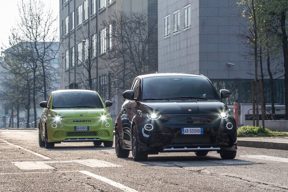 Black and green Abarth 500e models on a city street