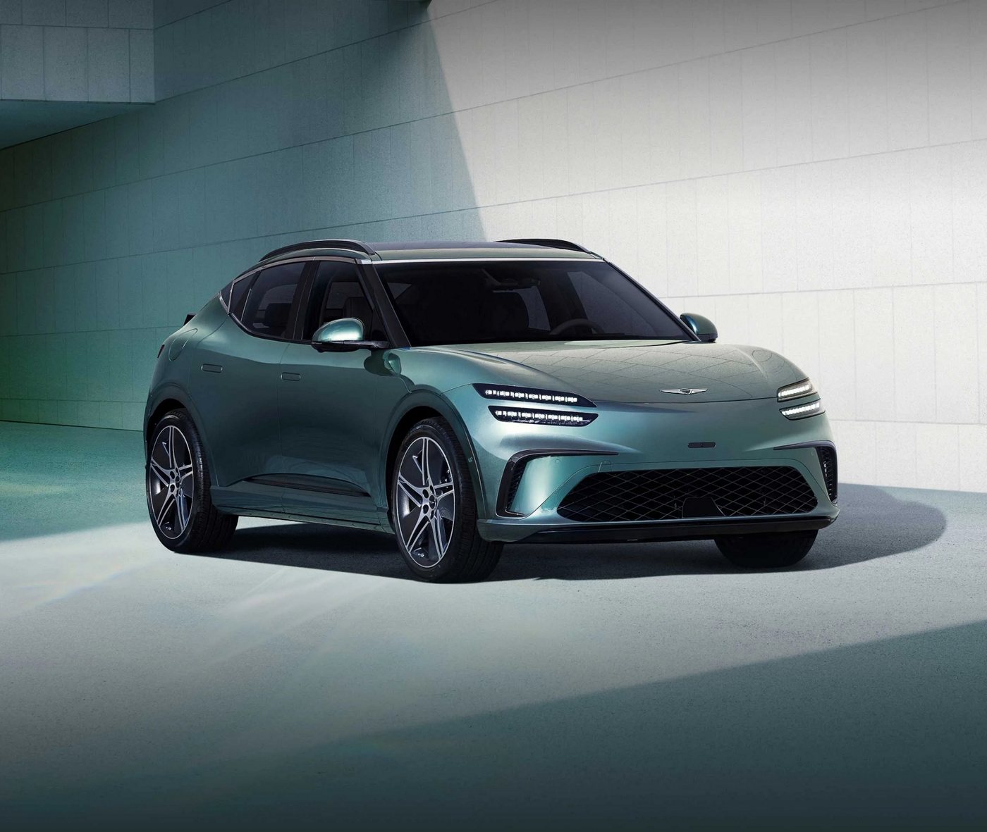 Green updated Genesis GV60 outside a modern building